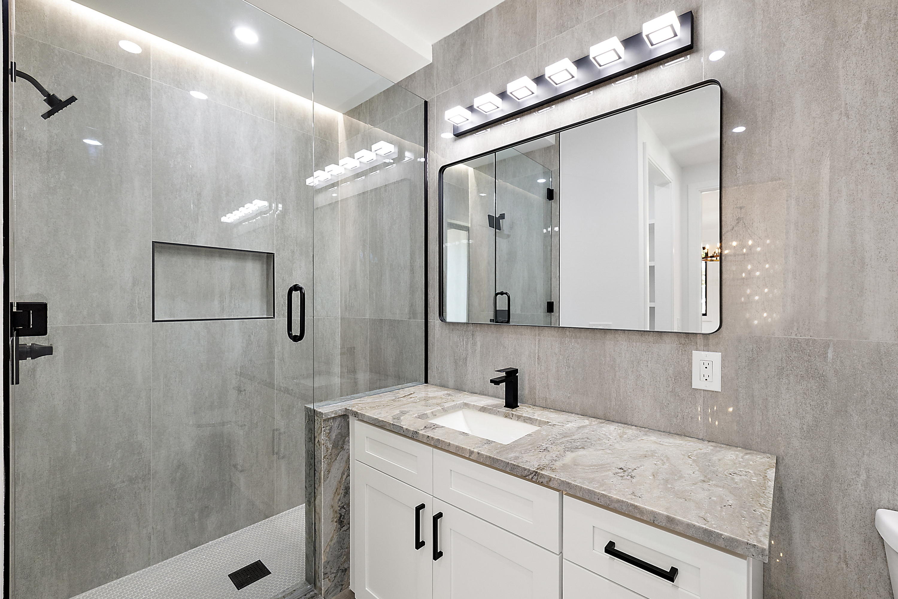 Modern guest bath with gray porcelain tile and glass shower