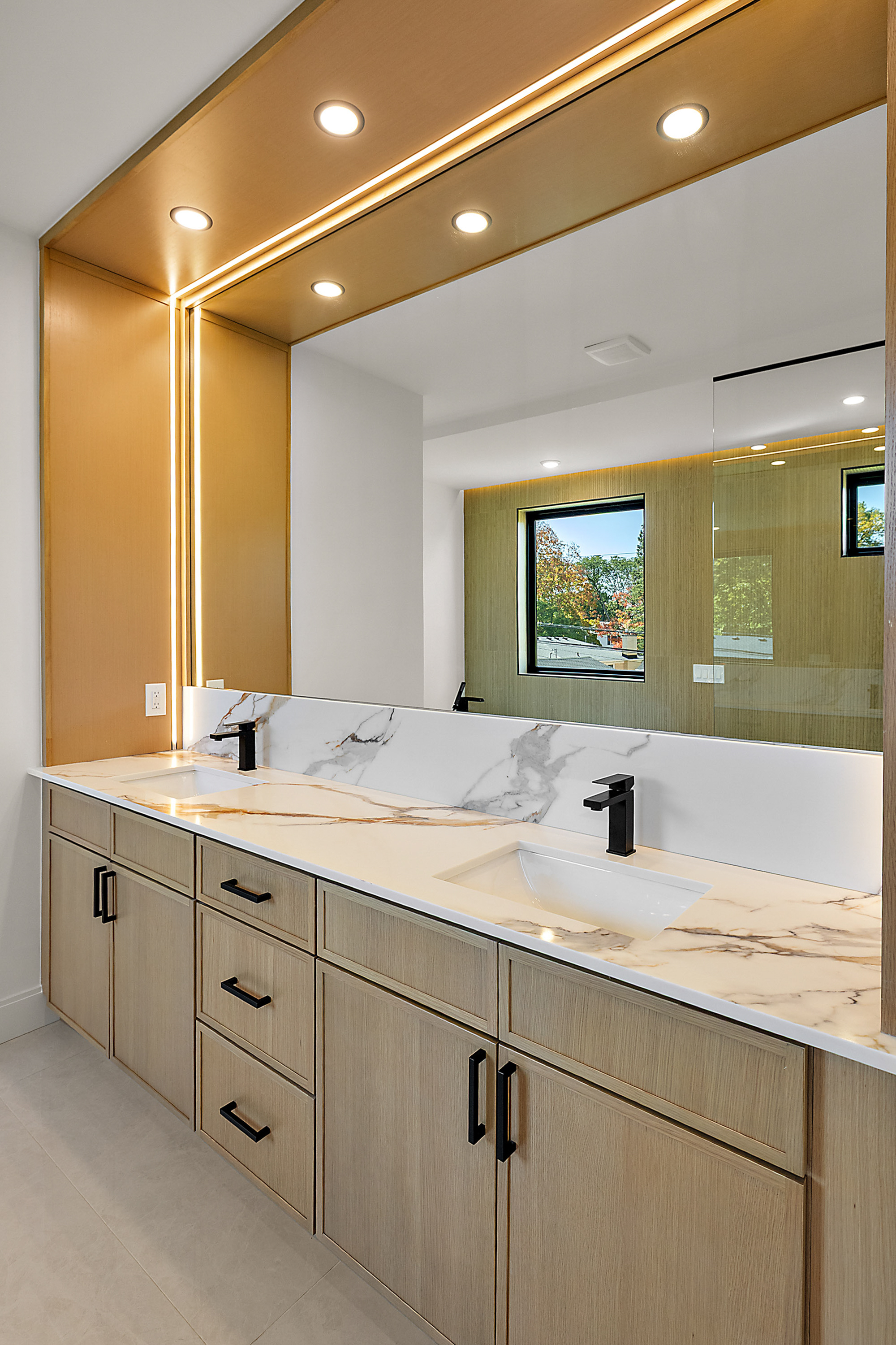Master bath double vanity with bookmatched marble counter and LED-cove ceiling