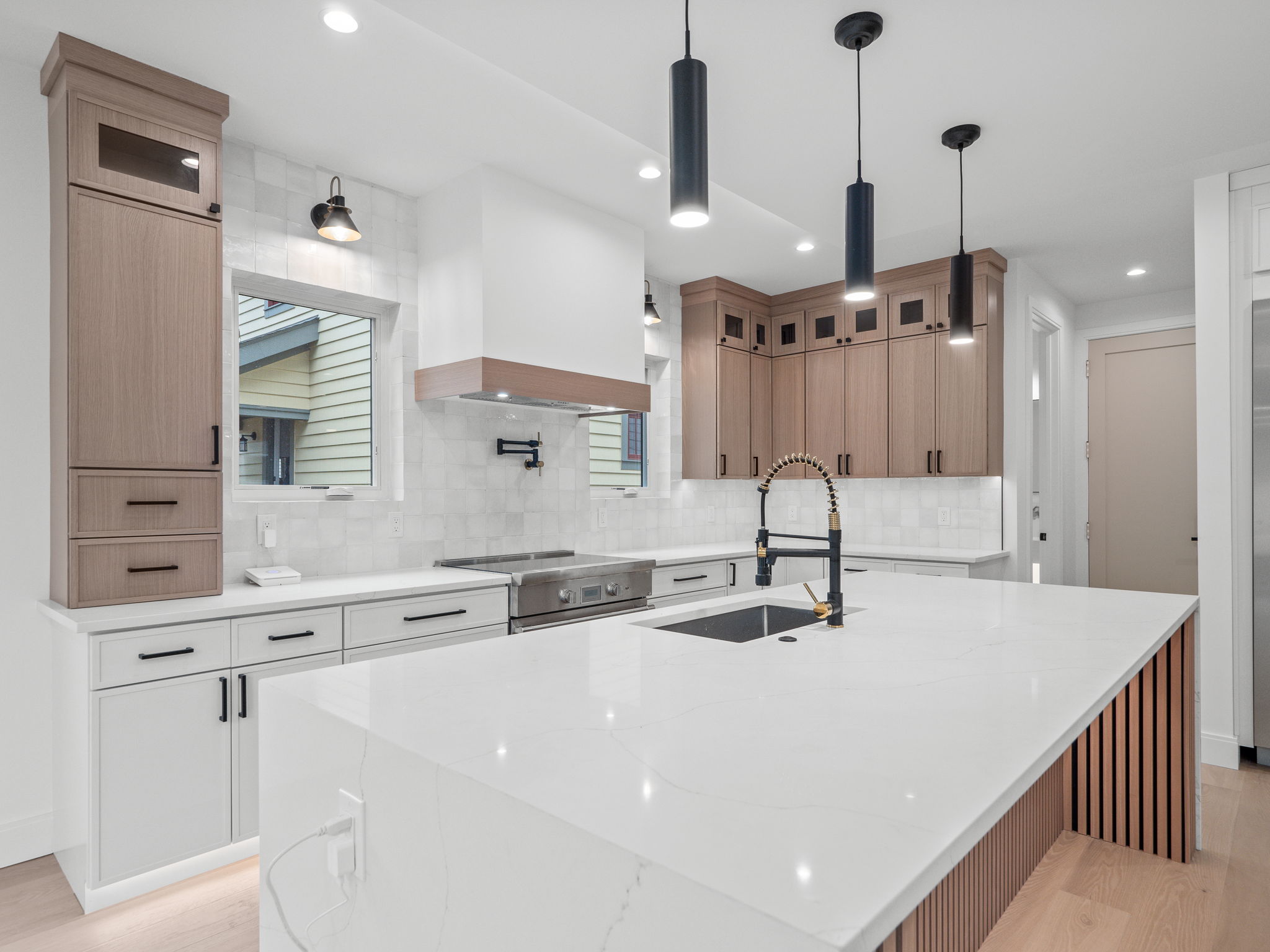 Custom kitchen with waterfall quartz island and white oak cabinetry